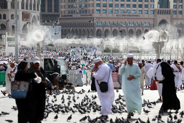 Men walk with umbrellas as people start arriving to perform the annual Haj in the Grand Mosque, in the holy city of Mecca, Saudi Arabia, June 24, 2023. REUTERS/Mohamed Abd El Ghany Asal Usul Gelar "Haji" di Indonesia, Ternyata Bukan dari Arab Saudi