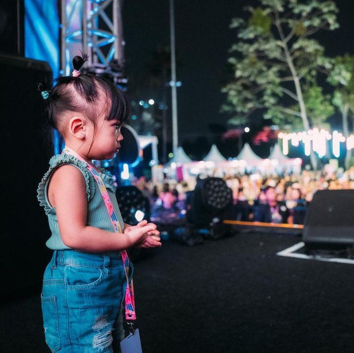 <p>Nakeya terlihat menggemaskan selama menemani kedua kakaknya. Bocah kelahiran November 2021 ini mengenakan pakaian serba biru dengan rambut yang dikuncir. (Foto: Instagram @riafinola)</p>