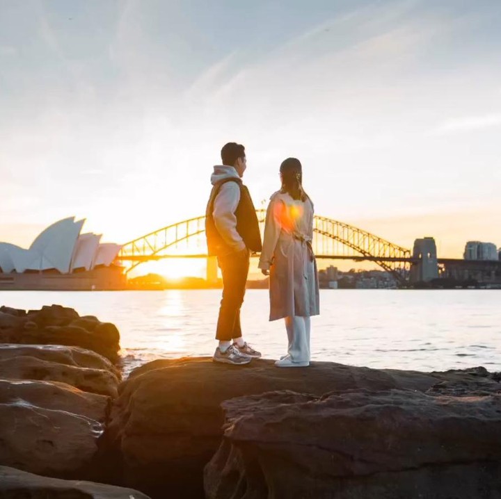 <p>Ginting melanar Mitzi di dekat Sydney Opera House, Australia. Suasana romantis terlihat saat Ginting melamar Mitzi di dekat sungai dengan pemandangan matahari terbenam. (Foto: Instagram @sinisukanthony)</p>