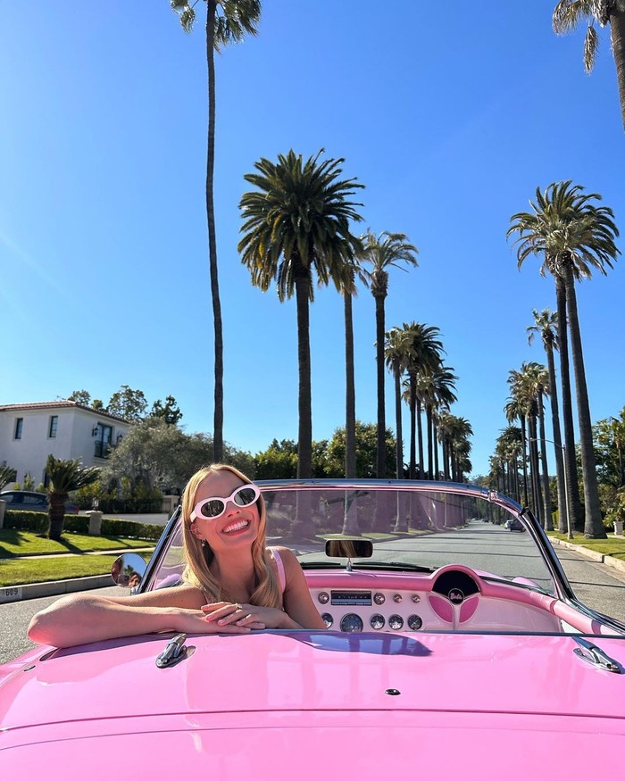 Margot Robbie berpose di sebuah mobil berwarna merah muda untuk menyambut Barbie Press Tour yang dimulai 26 Juni 2023/ Foto: instagram.com/barbiethemovie