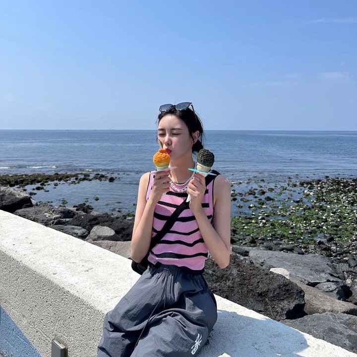 <p>Tampil lebih kasual, Lee Seung Hyun terlihat imut ketika menikmati es krim di tepi pantai. Ia mengenakan busana tanktop warna pink. (Foto: Instagram @is.hyun_)</p>