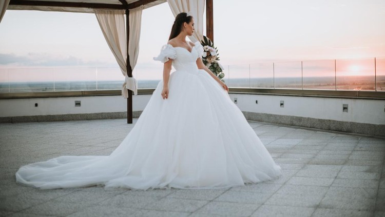 Beautiful bride posing in white princess dress with crown.