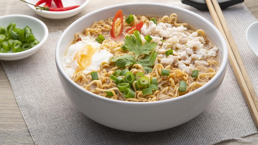 1398323127 Instant noodle soup with minced pork and boiled egg in white bowl on wood table