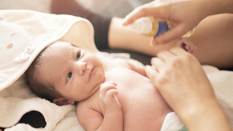 Mother makes massage with baby oil