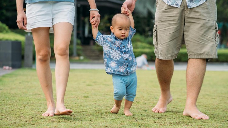 Ilustrasi Anak Menginjak Rumput Close up shot of an adorable baby boy having fun with his parent in their public park.