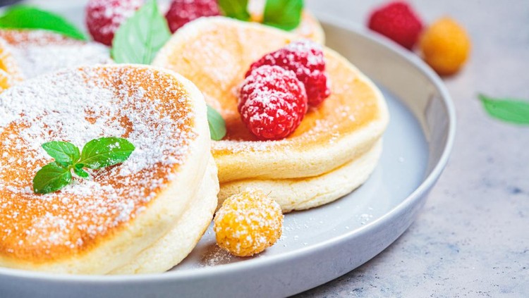 Japanese fluffy pancakes with raspberries in a gray plate, gray background. Japanese cuisine concept.
