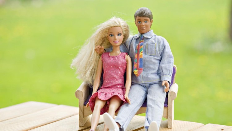 Tallinn, Estonia- May 19th, 2011. Barbie and Ken are sitting together outside. Ken has his arm wrapped around Barbie.
