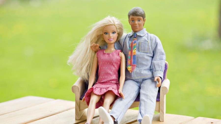 Tallinn, Estonia- May 19th, 2011. Barbie and Ken are sitting together outside. Ken has his arm wrapped around Barbie.