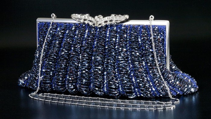 Blue evening bag over black background
