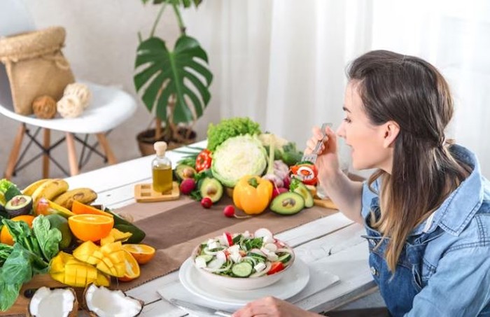 Perempuan sedang makan buah
