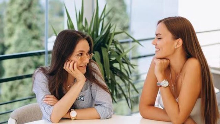 Dua perempuan sedang mengobrol