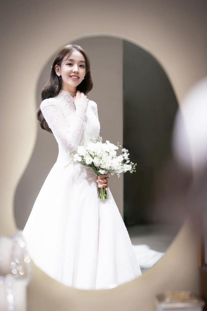 Ekspresi bahagia Baek A Yeon dalam menantikan hari pernikahan yang dapat terhitung dengan jari terpancar jelas dalam pantulan cermin. Senyum cerahnya melebihi keindahan buket bunga dalam genggaman./ Foto: instagram.com/ayeoniiiiii