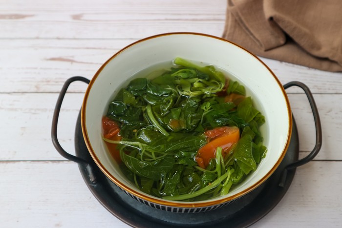 View of Clear vegetable spinach served on white bowl Isolated on white background