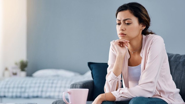 1172676619 Cropped shot of a young woman looking bored while sitting at home