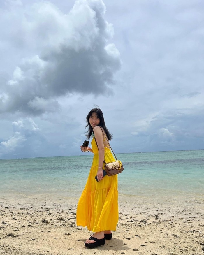 Dress kuning yang menyegarkan dan cerah ala Kang Mina ini cocok untuk kamu yang ingin pergi piknik ke pantai. Dress berwarna cerah memberikan nuansa ceria yang membuat tampilanmu lebih semangat./ Foto: kpopstarz.com