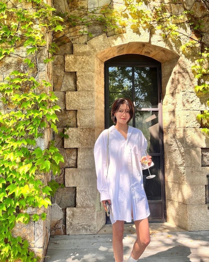 Jika kamu mencari dress yang sederhana, kemeja panjang putih klasik seperti yang dikenakan Sooyoung ini bisa menjadi inspirasi. Padukan dengan tas berwarna netral untuk tampil yang lebih elegan./ Foto: kpopstarz.com