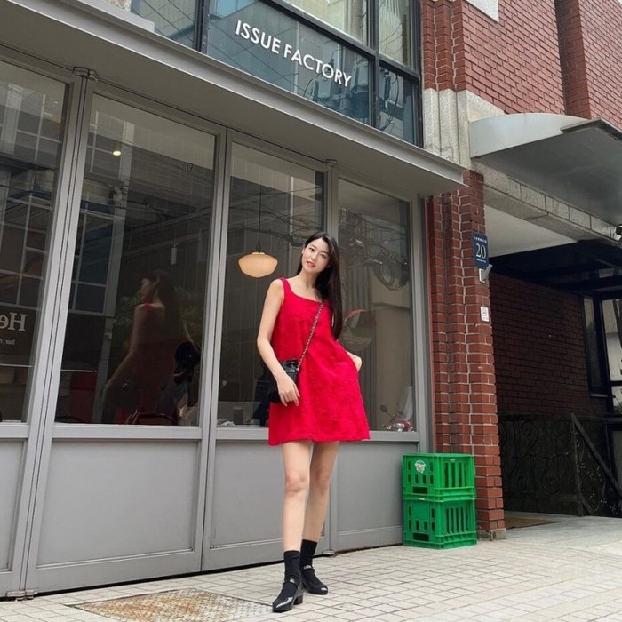 Jika kamu suka berjalan-jalan santai sambil memancarkan pesona yang sejuk, kamu bisa mencoba dress merah Kim Seolhyun dengan detail applique bunga alami. Kamu juga bisa menambahkan kaus kaki dan sepatu hitam ala Seolhyun./ Foto: kpopstarz.com