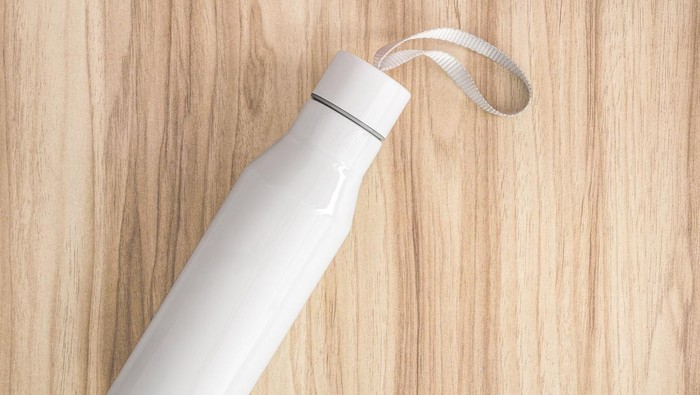 White water bottle on wood background. Insulated container for keep your drink.