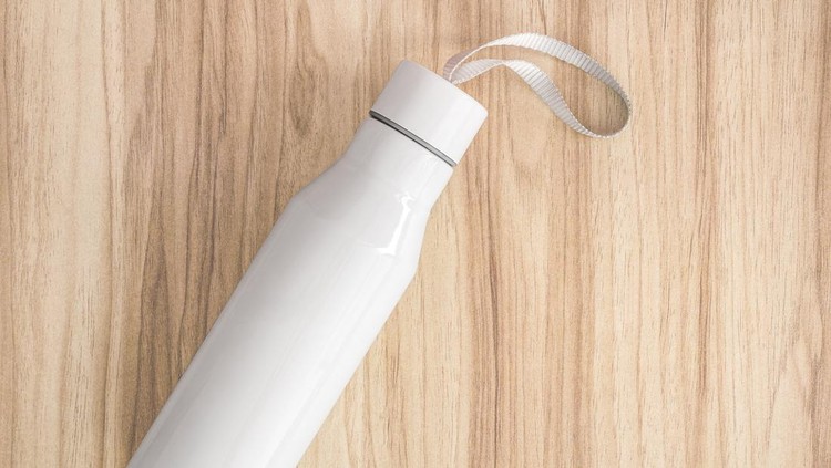 White water bottle on wood background. Insulated container for keep your drink.