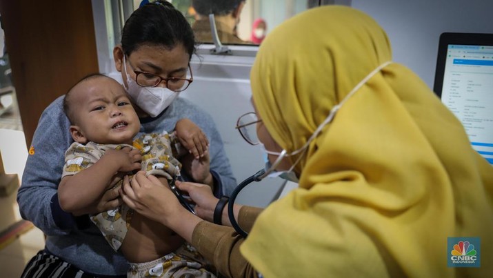 Dokter melakukan pemeriksaan kesehatan terhadap pasien bergejala Infeksi Saluran Pernapasan Akut (ISPA) di Puskesmas Kecamatan Mampang Prapatan, Jakarta Selatan, Selasa (15/8/2023). Tingginya angka polusi udara di Jakarta belakangan ini menyebabkan jumlah warga yang terinfeksi penyakit ISPA meningkat. (CNBC Indonesia/Faisal Rahman)