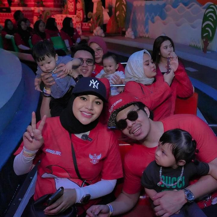 <p>Aurel terlihat mengenakan pakaian berwarna merah putih dengan jilbab, topi, dan celana hitam. Warna pakaian ini senada dengan keluarga dan karyawannya yang datang ke Dufan. (Foto: Instagram @attahalilintar)</p>