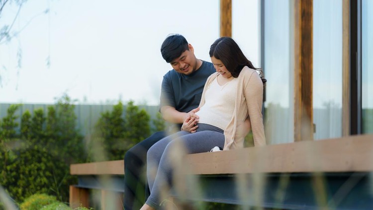 Asian pregnant woman with her husband talking together in terrace at home for relax and breath of fresh air.