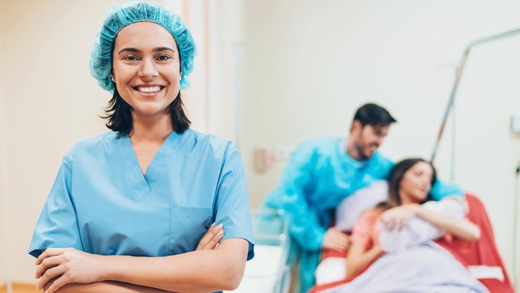 Pregnant young woman lying on the bed in delivery room. Side view of happy pregnant female resting on bed in hospital ward. Healthcare and pregnancy concept