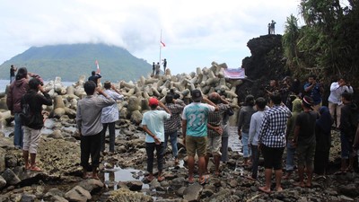 Sejumlah warga di Ternate merayakan HUT ke-78 RI dengan upacara pengibaran bendera setengah tiang di atas bebatuan karang, Kamis (17/8).
