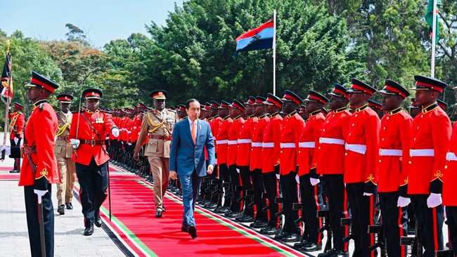 Jokowi saat bergegas masuk gedung langsung dihampiri tentara Kenya. Mereka mengingatkan masih ada tahapan yang mesti dilalui dalam upacara penyambutan.