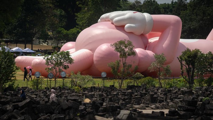 Pengunjung berada di dekat karya seni kontemporer seniman dunia Brian Donnelly atau KAWS saat pameran bertajuk Kaws : Holiday Indonesia di pelataran Candi Brahma di Kompleks Candi Prambanan, Sleman, D.I Yogyakarta, Sabtu (19/8/2023). Pameran yang menampilkan karya instalasi dengan panjang 45 meter dan tinggi mencapai 15 meter tersebut dipamerkan untuk publik mulai 19 hingga 31 Agustus 2023 mendatang. ANTARA FOTO/Andreas Fitri Atmoko/foc.