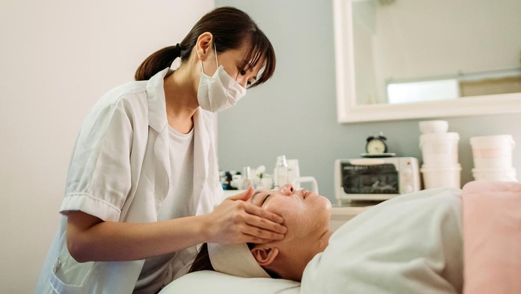 beautician applying mask for female customer
