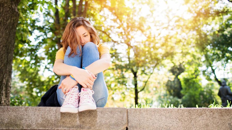 Teenage girl feeling depressed in the park