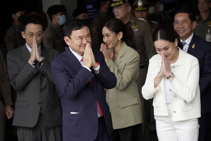 Thailand's former Prime Minister Thaksin Shinawatra, foreground, with, from left, his son Phantongtae, his daughters Pinthongta and Paetongtarn, arrives at Don Muang airport in Bangkok, Thailand, Tuesday, Aug. 22, 2023. (AP Photo/Sakchai Lalit)