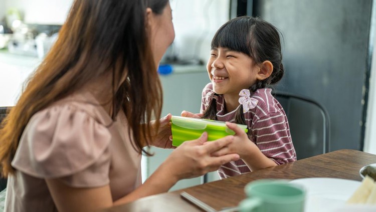 Ilustrasi Tas Bekal Anak Image of Asian mother making healthy school lunch box for her daughter. Mother giving her daughter the healthy sandwich.