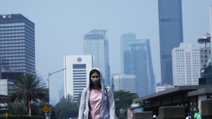 Warga menggunakan masker melintas di jalan pedestrian, Jakarta, Jumat (25/8). (CNBC Indonesia/Tri Susilo)