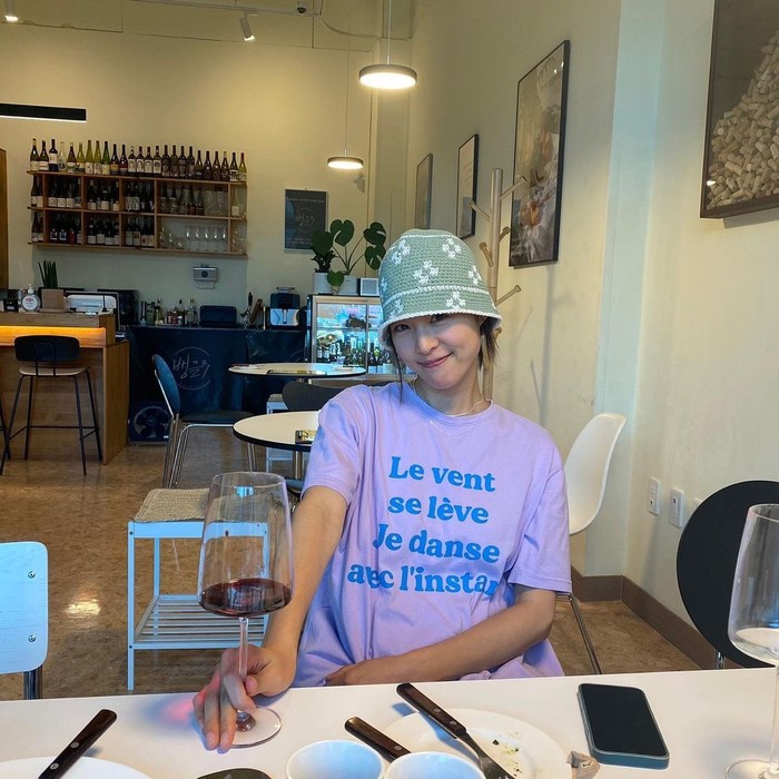 Topi rajut memiliki pesona vintage yang unik dan nyaman. Lee Yeon Hee memadukan topi rajut hijau dengan pola bunga putih dengan kaus berwarna ungu. Ia melengkapi topi rajut tersebut sebagai item point yang indah./ Foto: vogue.co.kr