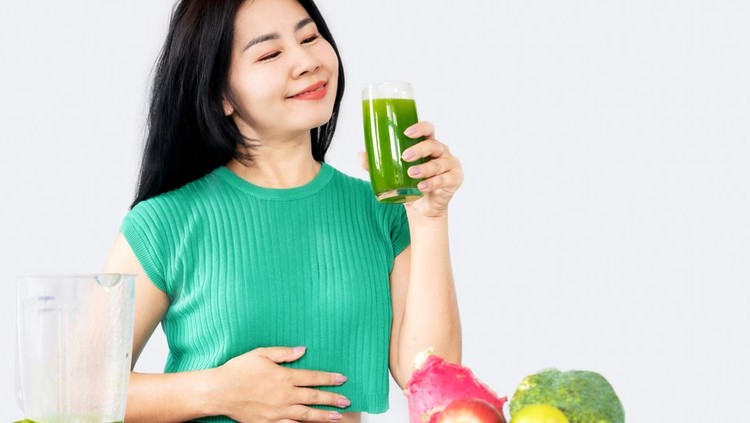 Minum jus healthy Asian woman drinking mix of green vegetables and fruit juice for detox and diet