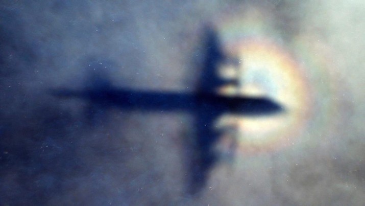 FILE - In this March 31, 2014 file photo, the shadow of a Royal New Zealand Air Force P3 Orion is seen on low level cloud while the aircraft searches for missing Malaysia Airlines Flight MH370 in the southern Indian Ocean, near the coast of Western Australia. An independent investigation report released Monday, July 30, 2018,  more than four years after Malaysia Airlines Flight 370 disappeared highlighted shortcomings in the government response that exacerbated the mystery.(AP Photo/Rob Griffith, File)