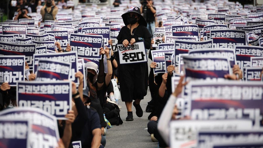 South Korean teachers take part in a protest to demand better protection of their rights, the normalization of public education and to mourn a young teacher found dead in July in an apparent suicide, in Seoul, South Korea, September 4, 2023. The signs read "Vote for an agreement on the protection of teachers' rights."  REUTERS/Kim Hong-Ji