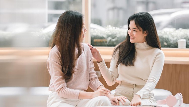 Asian beautiful women smiling and talking together in coffee shop. Lifestyle and Winter Concept.