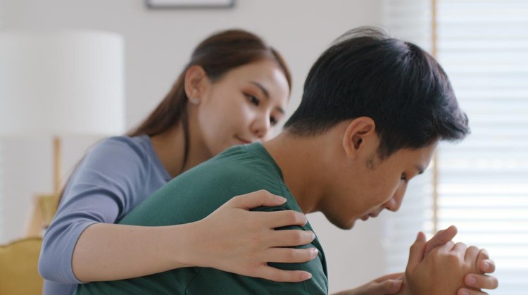 Asia young people stress relief trust talk share suffer cancer pain sick family loss bad news crisis. Sorrow cry man and carer woman sit at sofa home help listen by love hold hand warm hug touch wife.