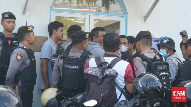 Massa penolak kehadiran Rocky Gerung dan Refly Harun masih bertahan di luar lokasi acara dengan membentuk barikade. Kepolisian melakukan pengawalan ketat.