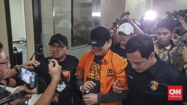 Tersangka kasus kepemilikan senjata api ilegal Dito Mahendra tiba di Bareskrim Polri setelah sebelumnya ditangkap di wilayah Bali, Jumat (8/9).
