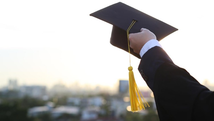 A picture of a man holding a graduation hat