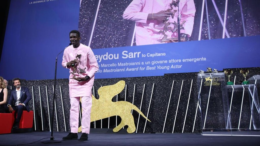 1670158054 VENICE, ITALY - SEPTEMBER 09: Seydou Sarr with the Marcello Mastroianni Award for Best New Young Actor or Actress for film ‘Io Capitano’ on stage during the Awards ceremony at the 80th Venice International Film Festival on September 09, 2023 in Venice, Italy. (Photo by Daniele Venturelli/WireImage)