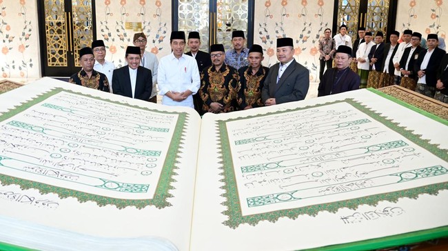 Presiden Jokowi menerima mushaf Alquran raksasa saat mampir di Masjid Mohammed bin Zayed, Kota Surakarta untuk salat Duha.