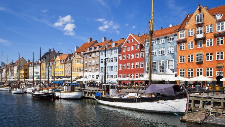 Nyhavn is a 17th century waterfront, canal and entertainment district in Copenhagen, Denmark. Stretching from Kongens Nytorv to the harbour front just south of the Royal Playhouse, it is lined by brightly coloured 17th and early 18th century townhouses and bars, cafes and restaurants. Serving as a 