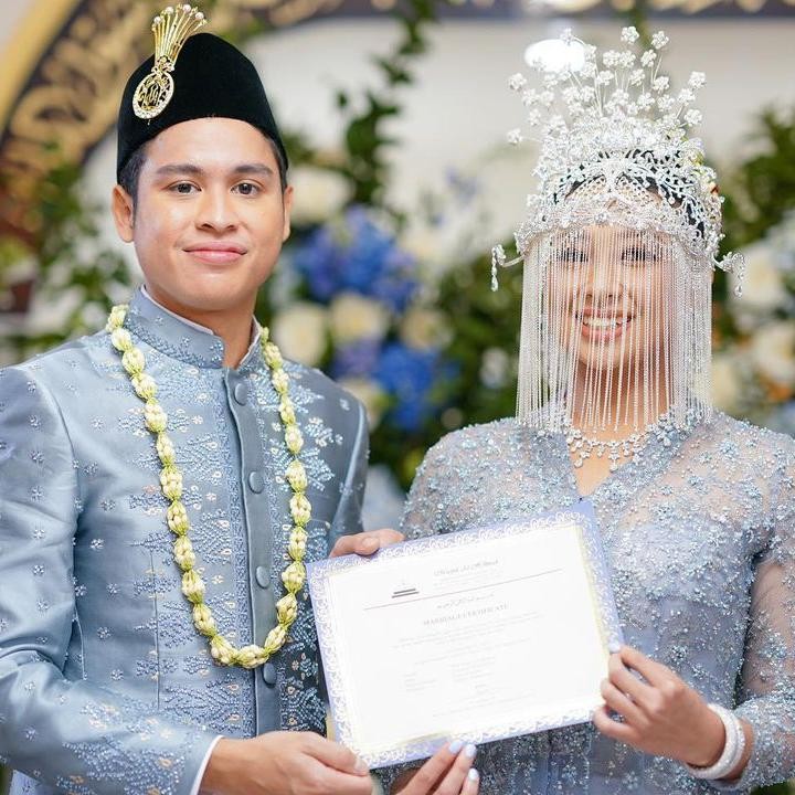 <p>Atheera dan Panji tampak serasi mengenakan pakaian adat Betawi di acara akad nikah. Pasangan ini memakai baju pernikahan adat berwarna abu-abu kebiruan. Atheera terlihat mengenakan aksesoris kepala khas adat Betawi. (Foto: Instagram @sandiuno)</p>