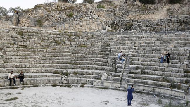 Palestinians sit in the Roman amphitheatre in Sebastia, as Palestinian residents fear losing access to the archaeological site after Israel announced it is allocating 32 million Shekels to develop the site, near Nablus in the Israeli-occupied West Ba