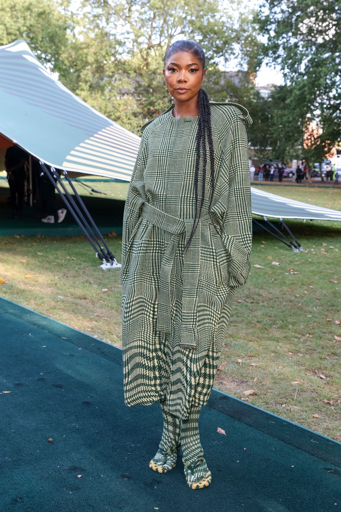 Penampilan Gabrielle Union kian berkesan berkat motif yang saling bertabrakan, tapi semuanya dalam warna senada. Mulai dari coat plaid, kaus kaki houndstooth, hingga sandal stripes yang dikenakannya buat gaya ekstra mencolok. Foto: Dave Benett/Dave Benett